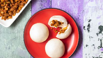 Tre bao al vapore, uno con un morso. 