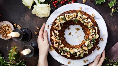 Torta con frutta secca e verde, candele e fiori. 