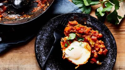 Uovo in camicia su salsa di pomodoro piccante e erbe. 