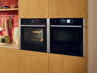 Две интегрирани фурни с подгряващи чекмеджета една до друга във високи кухненски шкафове