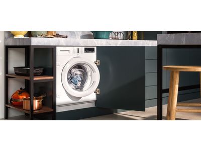 A kitchen featuring a washing machine beside a sink, showcasing a functional and practical home environment.
