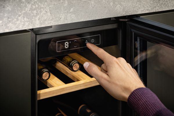 Uomo che imposta la temperatura ideale per il vino bianco della cantinetta NEFF