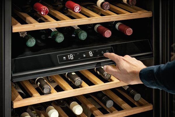 Uomo che imposta la temperatura ideale per il vino rosso della cantinetta NEFF