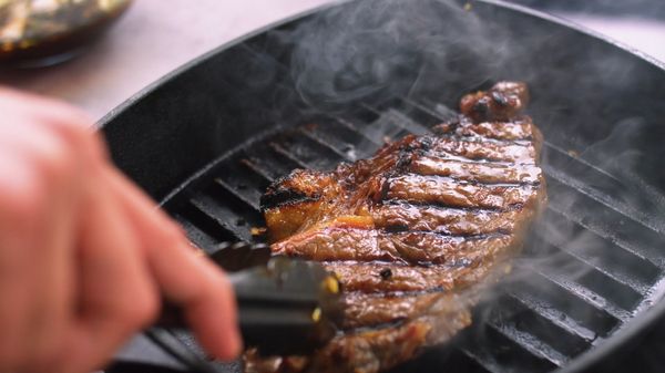 Steak cooking in a griddle pan