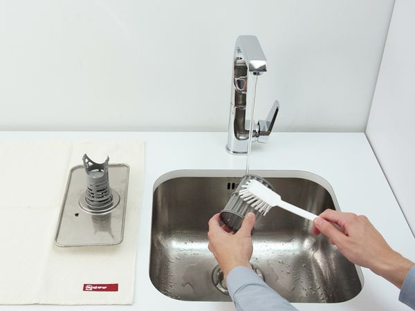 Reinigen und spülen Sie beide Filtereinheiten unter fließendem Wasser, bis sie frei von Rückständen sind.