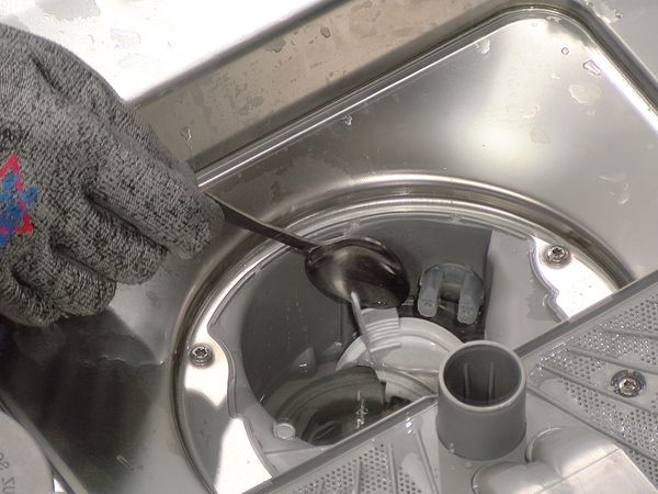 Après avoir nettoyé le filtre, utilisez une cuillère à café et retirez le couvercle de la pompe.
