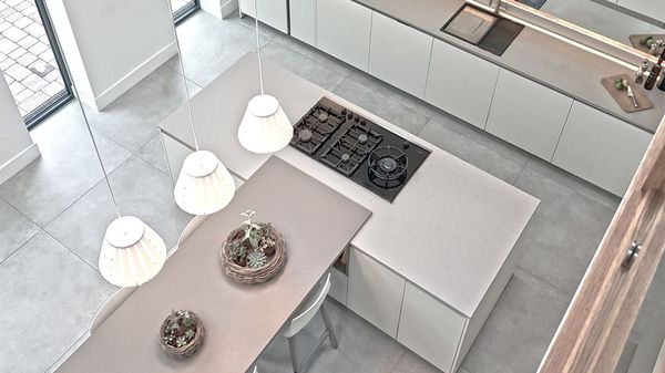 Minimalist grey and white kitchen with gas hob on island