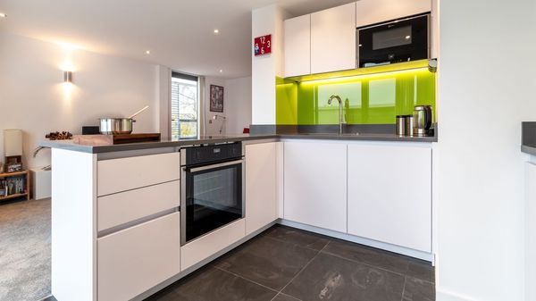 White minimalist kitchen concealing appliances