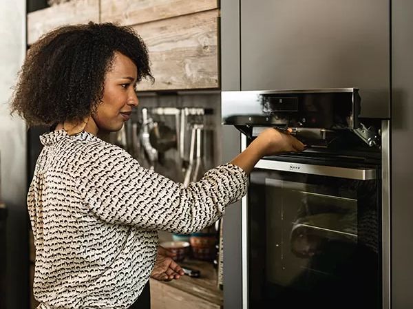Woman standing next to an oven