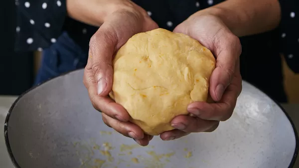 Hands holding dough
