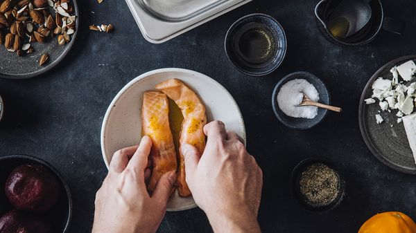 Two piece of salmon on a plate with seasonings