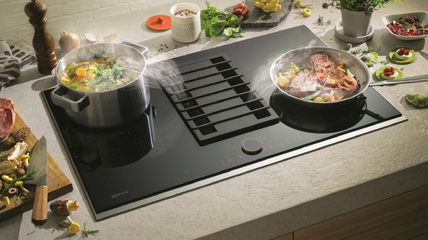 Food cooking in pans on vented hob