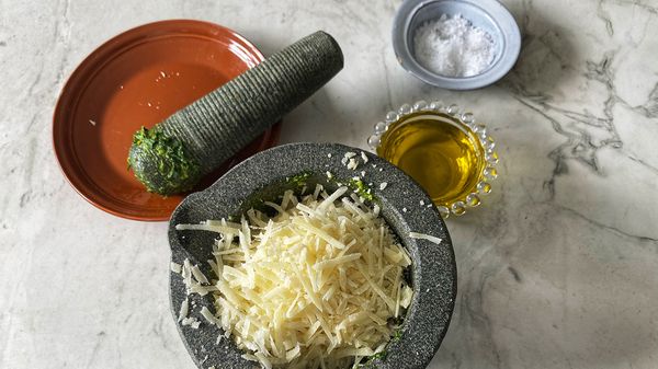Stamp alles tot een egale pasta, en voeg dan de kaas toe en giet de olijfolie er langzaam bij. Als alles goed gemengd is zet je de pesto opzij.
