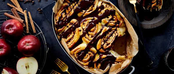 Overhead shot of cinnamon rolls with dark chocolate drizzle dish in tray