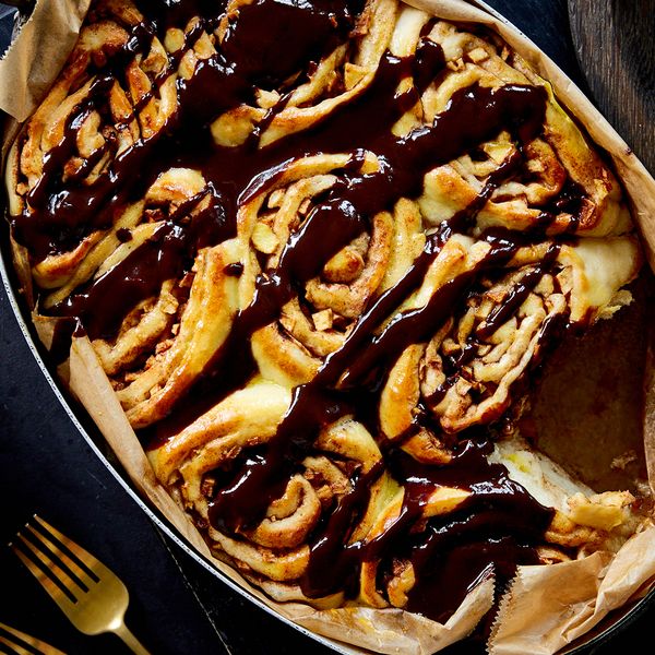 Overhead shot of cinnamon rolls with dark chocolate drizzle dish in tray
