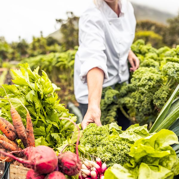 Giovane donna che fa la spesa all’aperto, acquistando frutta e verdura di stagione