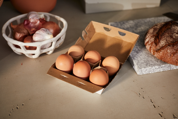 Confezione da sei uova aperta sul tavolo della cucina