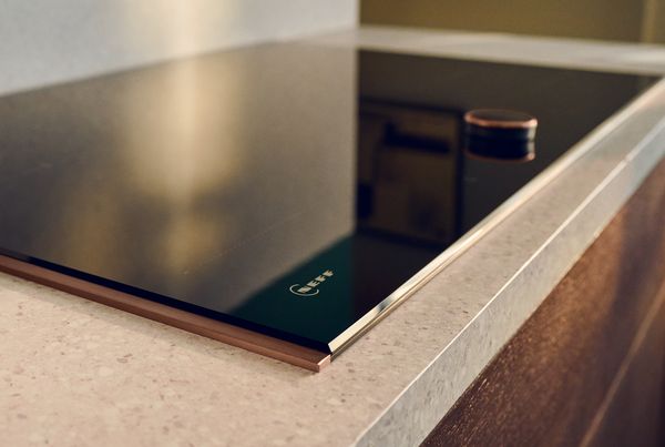 Близък план на готварски плот Neff с TwistPad управление и бронзова рамка