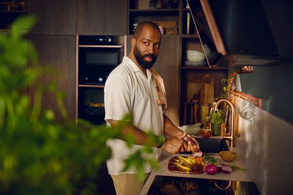 Uomo che affetta verdure fresche in cucina