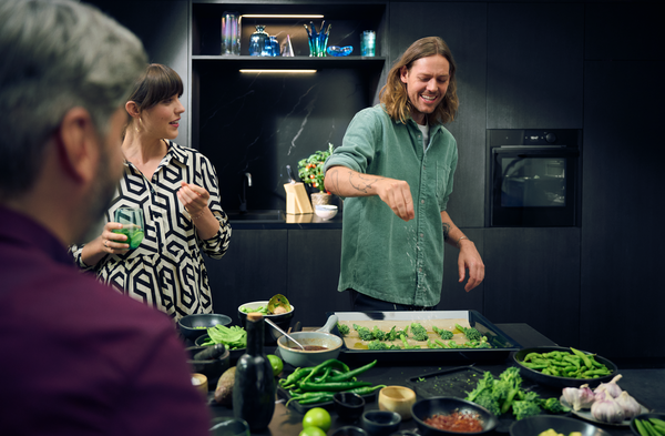 Robert Ames mit Freunde in Anthrazit Küche beim Kochen