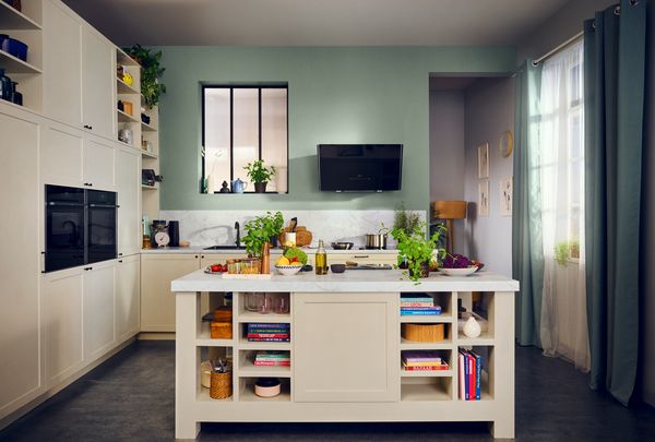 Cucina moderna rinnovata con pareti verde salvia e isola centrale bianca