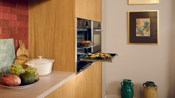 Slide & Hide®-oven open met bakplaat vol courgettes in de keuken van Anahita 