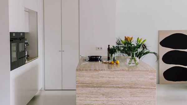 Weiß matte Küche mit einer Kücheninsel aus Naturstein