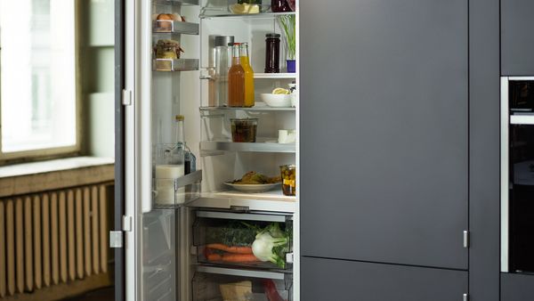 A built-in open fridge-freezer combination to the right of a large window