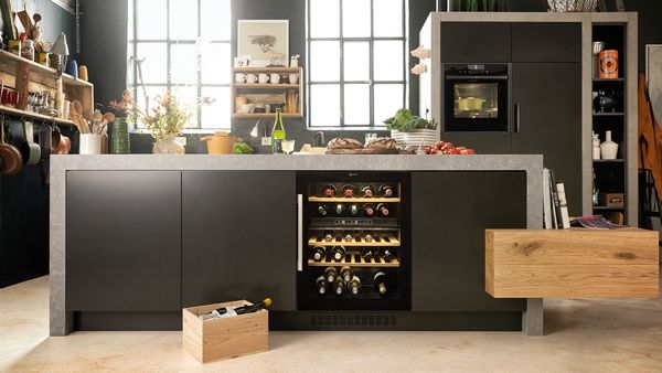 A wine cooler integrated in the kitchen island of a grey kitchen