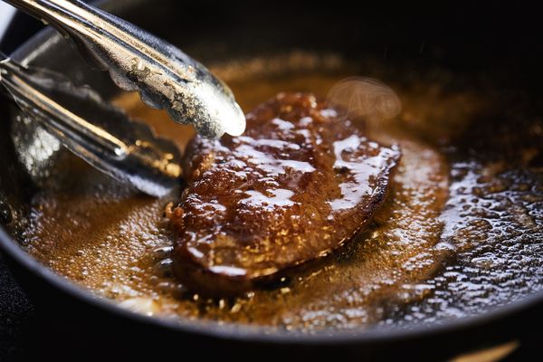 Bistecca che cuoce in padella