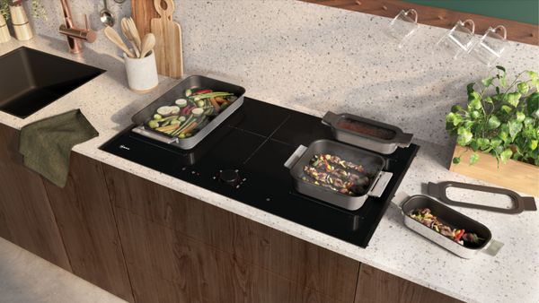 Kookplaat met kookpot, grillpan en enkele kleurrijke groenten, inclusief intuïtieve Flex Zone 