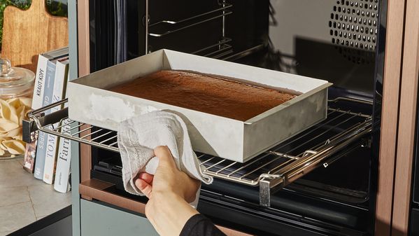 Putting mixture in tray in oven