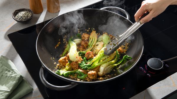 Stap 4: Voeg ondertussen sesamolie, paksoi en de kleingesneden lente-uitjes, knoflook en chilipeper toe aan een koekenpan of wok.