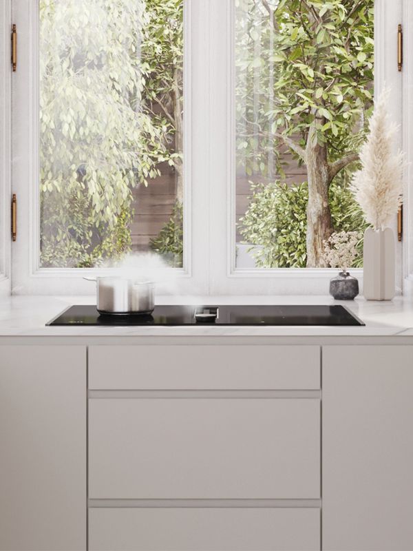 Šviesios šiuolaikinės virtuvės vaizdas su kaitlente su integruota ventiliacija po langu