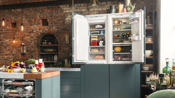 Tilava keittiö, jossa on Side-by-Side-jääkaappi, jonka ovet ovat auki