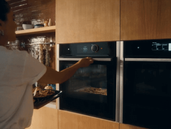 Person putting food in slide and hide oven