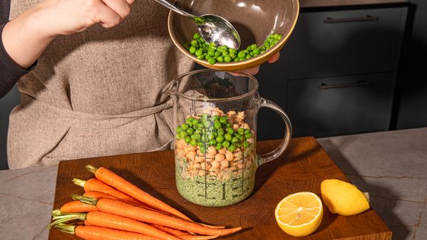 Adding chopped ingredients with chickpeas in a measuring jug