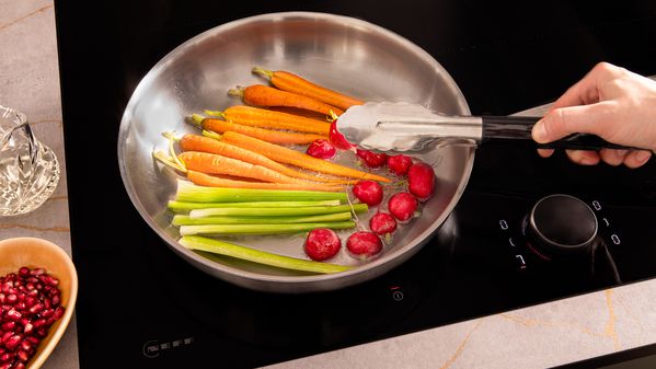 Frying sliced vegetables in a frying pan