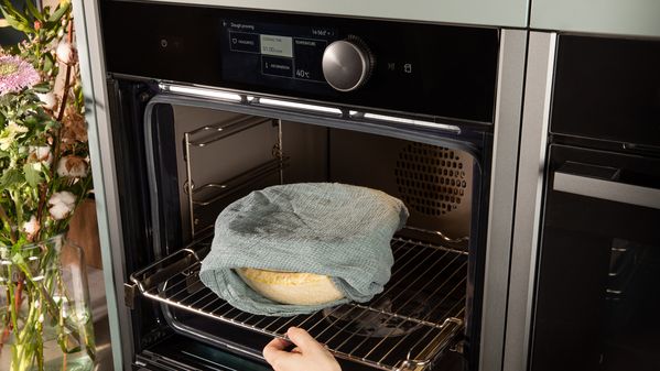 Putting the dough in the oven for rising