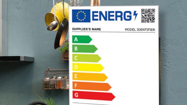 Az energiacímke egy konyhafalról készült képre van helyezve, ahol edények és egy fűszertartó lóg