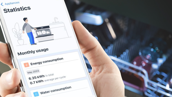 Person bedient die Smart Start Funktion eines NEFF Geschirrsp&uuml;lers &uuml;ber die Home Connect App auf dem Smartphone in der K&uuml;che