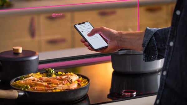 A person using an iPhone to capture a photo of a delicious cooking dish.
