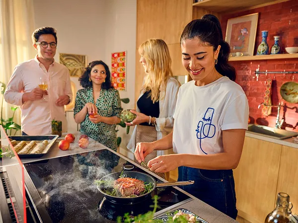 Tumman tyylik&auml;s keitti&ouml;, jossa on useita Neffin laitteita ja tasoilla aineksia ruoanlaittoa varten.