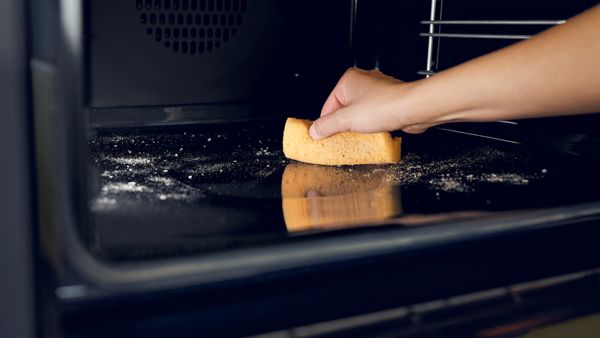 Women cleaning an oven cavity