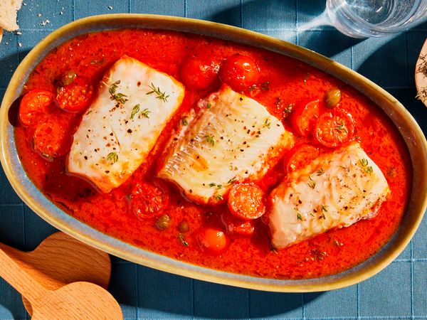 Poached cod in tomato sauce served on a serving platter