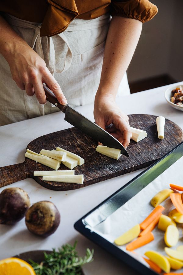 Vegetables chopped on rustic wooden chopping board. 