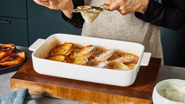 Dusting the French toast casserole with powdered sugar