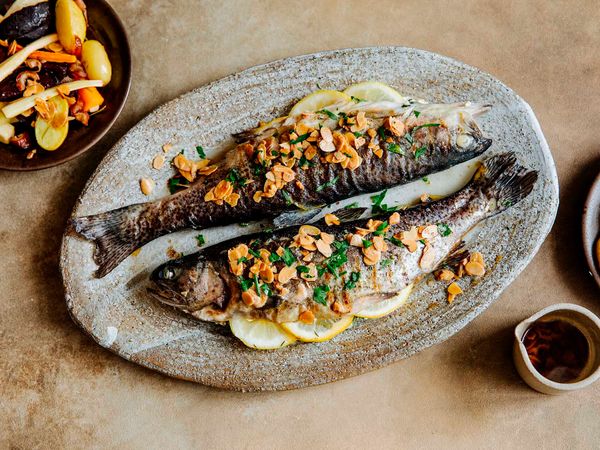 Two juicy trouts cooked and presented on a ceramic plate ready for serving.