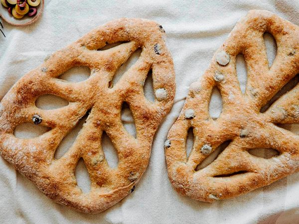 Freshly baked fougasse bread presented on a white cloth.