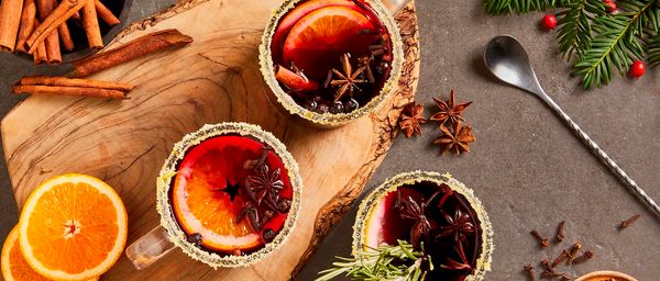 Mulled wine in glasses with wood board and festive background